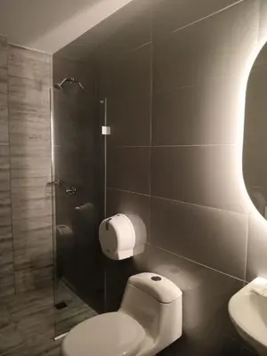a bathroom with a toilet and a glass shower at Hotel San Sebastian Real in Cartagena de Indias