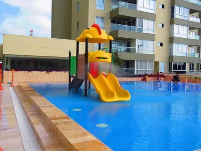 a swimming pool with a slide in the middle of it at Apartamentos Oceana - Cerca al Buenavista by SOHO in Barranquilla