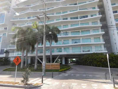 a large white building with palm trees in front of it at Morros Epic in Cartagena de Indias
