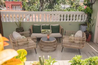 a patio with wicker chairs and a couch and a table at Hotel Casa La Fe in Cartagena de Indias