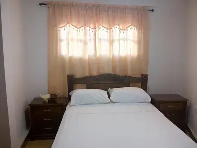 a bedroom with a bed with two pillows and a window at Hostal Casa de Barajas in Cartagena de Indias