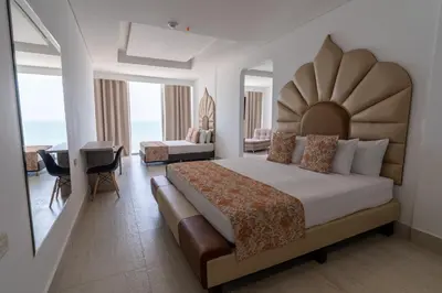 a bedroom with a king sized bed and a desk at Hotel Cartagena Dubai in Cartagena de Indias