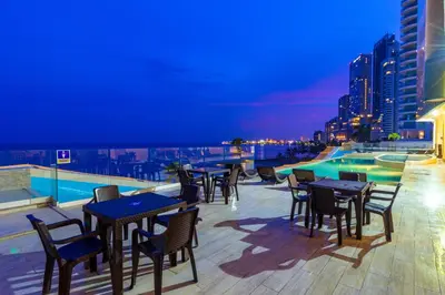 a rooftop patio with tables and chairs at night at Hotel Cartagena Dubai in Cartagena de Indias