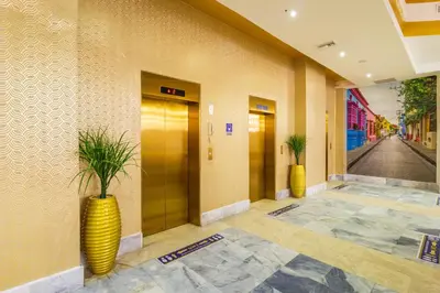 a lobby with a yellow vase with plants in it at Hotel Cartagena Dubai in Cartagena de Indias