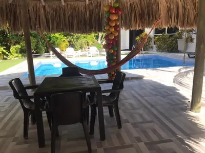 a hammock in a resort with a table and chairs at Carmela Beach in Tubará