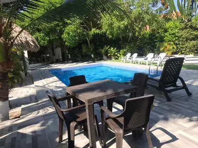 a table and chairs next to a swimming pool at Carmela Beach in Tubará