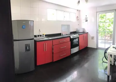a kitchen with red cabinets and a stainless steel refrigerator at Carmela Beach in Tubará
