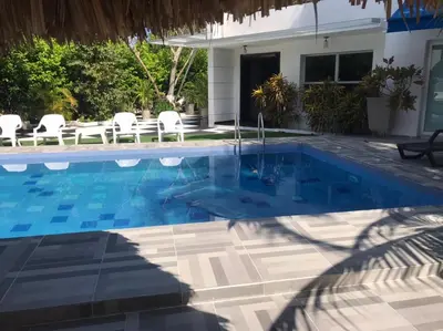 a swimming pool in front of a house at Carmela Beach in Tubará