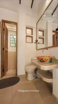 a bathroom with a toilet and a mirror at Casa de Playa Moñitos Laguito in Moñitos