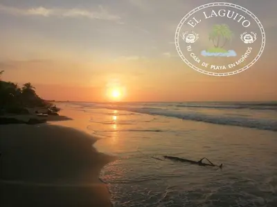 a picture of the beach at sunset with a coconut tree at Casa de Playa Moñitos Laguito in Moñitos