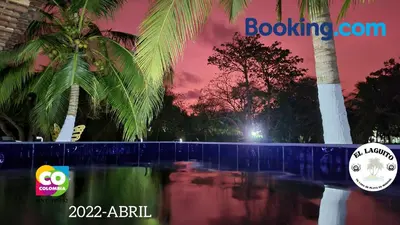a pool of water with palm trees at night at Casa de Playa Moñitos Laguito in Moñitos