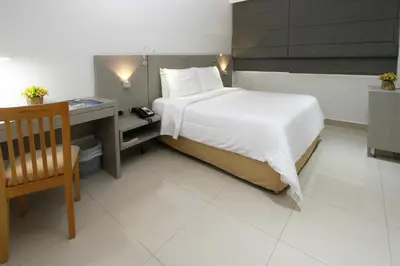 a bedroom with a bed and a desk and a bed at Hotel Barranquilla Plaza in Barranquilla