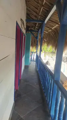 a hallway of a building with a thatched roof at Milimar Hostal in San Onofre