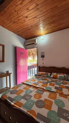 a bedroom with a bed with a colorful quilt on it at Milimar Hostal in San Onofre