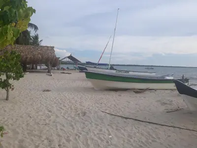 a boat sitting on a beach next to the ocean at Milimar Hostal in San Onofre