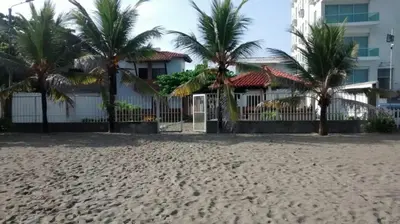 a house on the beach with palm trees at Cabaña Coveñas in Coveñas