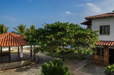 a house with a tree in front of a building at Cabaña Coveñas in Coveñas