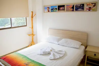 a bedroom with a bed with two towels on it at Hotel Iraka Zenu in Sincelejo