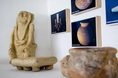 a statue and a vase next to a wall with pictures at Hotel Iraka Zenu in Sincelejo