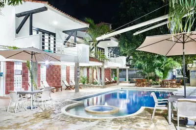 a swimming pool with chairs and tables and umbrellas at Santorini Villas Santa Marta in Santa Marta