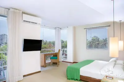 a bedroom with a bed and a large window at Hotel Santorini Resort in Santa Marta
