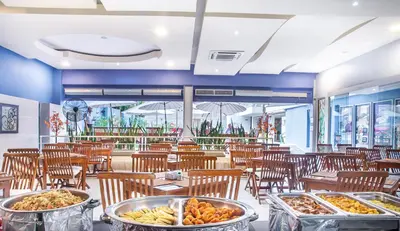 a restaurant with tables and chairs and food on display at Hotel Santorini Resort in Santa Marta