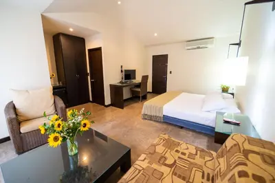 a hotel room with a bed and a living room at Hotel Santorini Express y Cabañas in Santa Marta