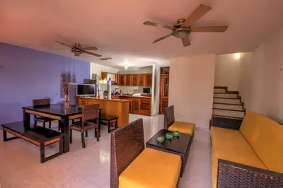 a living room and dining room with a ceiling fan at Hotel Santorini Express y Cabañas in Santa Marta