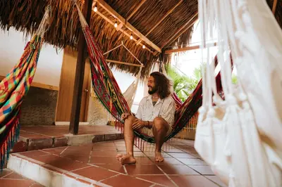 a man sitting in a hammock in a room at Viajero Cartagena - Centro Hostel in Cartagena de Indias