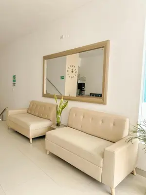 a living room with two couches and a mirror at Hotel Ginebra Sincelejo in Sincelejo