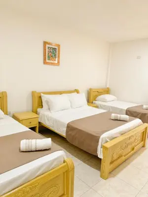 a room with three beds in a room at Hotel Ginebra Sincelejo in Sincelejo