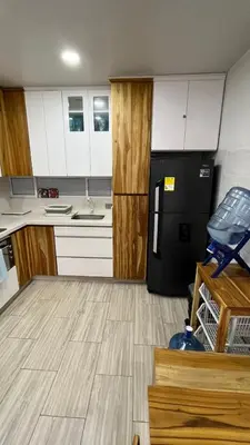 a kitchen with white cabinets and a black refrigerator at Espectacular cabaña en Coveñas - Sucre, Frente al mar!!! in Coveñas