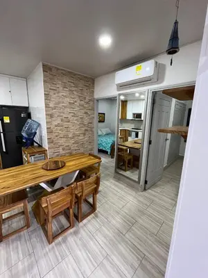 a living room with a table and a kitchen at Espectacular cabaña en Coveñas - Sucre, Frente al mar!!! in Coveñas