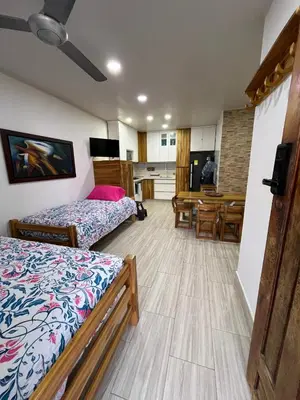 a room with two beds and a kitchen and a table at Espectacular cabaña en Coveñas - Sucre, Frente al mar!!! in Coveñas