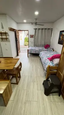 a room with two beds and a table and a bench at Espectacular cabaña en Coveñas - Sucre, Frente al mar!!! in Coveñas