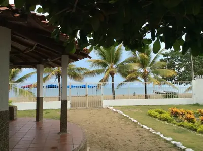 a pathway with palm trees and the beach in the background at Espectacular cabaña en Coveñas - Sucre, Frente al mar!!! in Coveñas