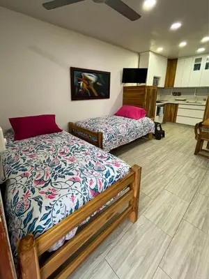 two beds in a room with a kitchen at Espectacular cabaña en Coveñas - Sucre, Frente al mar!!! in Coveñas