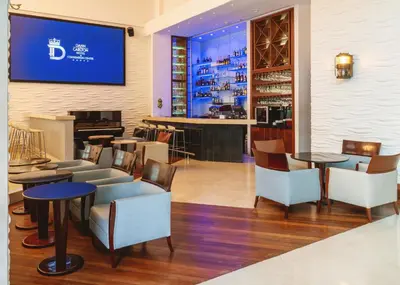 a restaurant with tables and chairs and a bar at Hotel Dann Carlton Barranquilla y Centro de Convenciones in Barranquilla