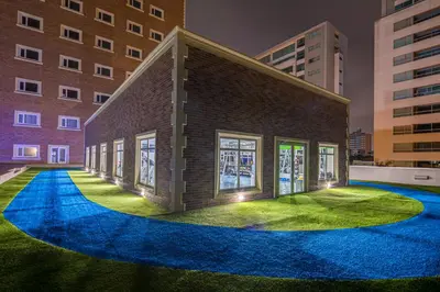 a small brick building with lights on the grass at Hotel Dann Carlton Barranquilla y Centro de Convenciones in Barranquilla