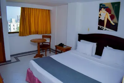 a hotel room with a bed and a window at Hotel Casa Ballesteros in Barranquilla