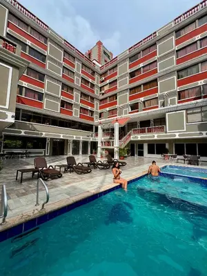 two people sitting in a swimming pool in a hotel at Hotel Casa Ballesteros in Barranquilla