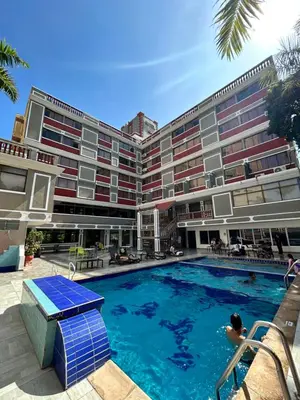 a hotel with a swimming pool in front of a building at Hotel Casa Ballesteros in Barranquilla