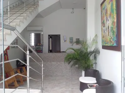 a staircase in a room with a table and a plant at Perla De La Sabana in Corozal