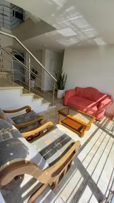 a living room with a red couch and tables at Perla De La Sabana in Corozal