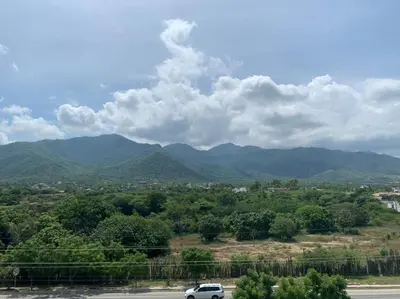 a car driving down a road with mountains in the background at Hotel West Plaza in Santa Marta