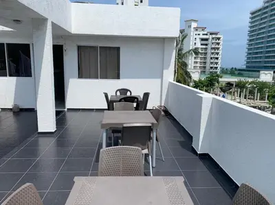 a balcony with tables and chairs on a building at Hotel West Plaza in Santa Marta