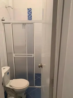 a bathroom with a toilet and a glass shower at Hotel West Plaza in Santa Marta