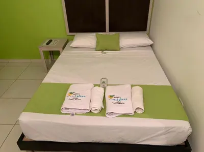 a bedroom with two beds with towels on them at Hotel West Plaza in Santa Marta