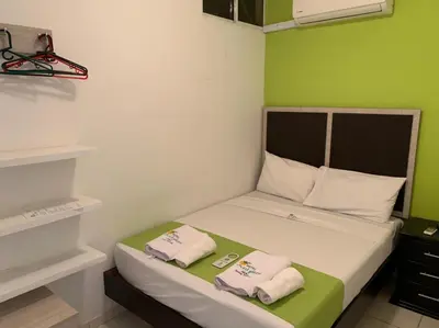 a small room with a bed with two towels on it at Hotel West Plaza in Santa Marta