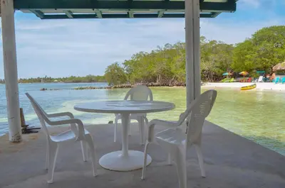a table and chairs with a view of the water at Hotel Puntanorte in Tintipan Island